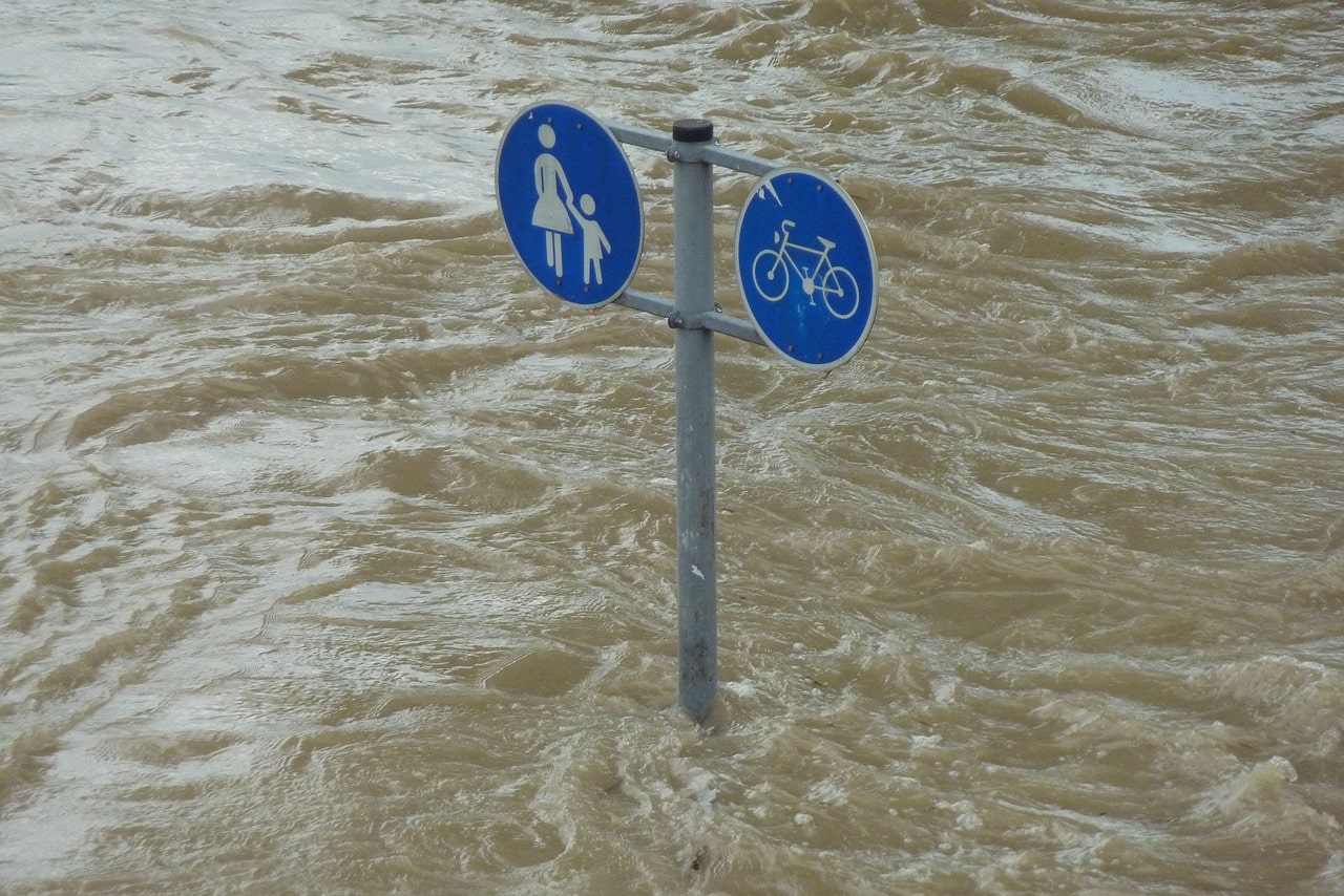 泥水に飲み込まれる歩行者サインと自転車サイン