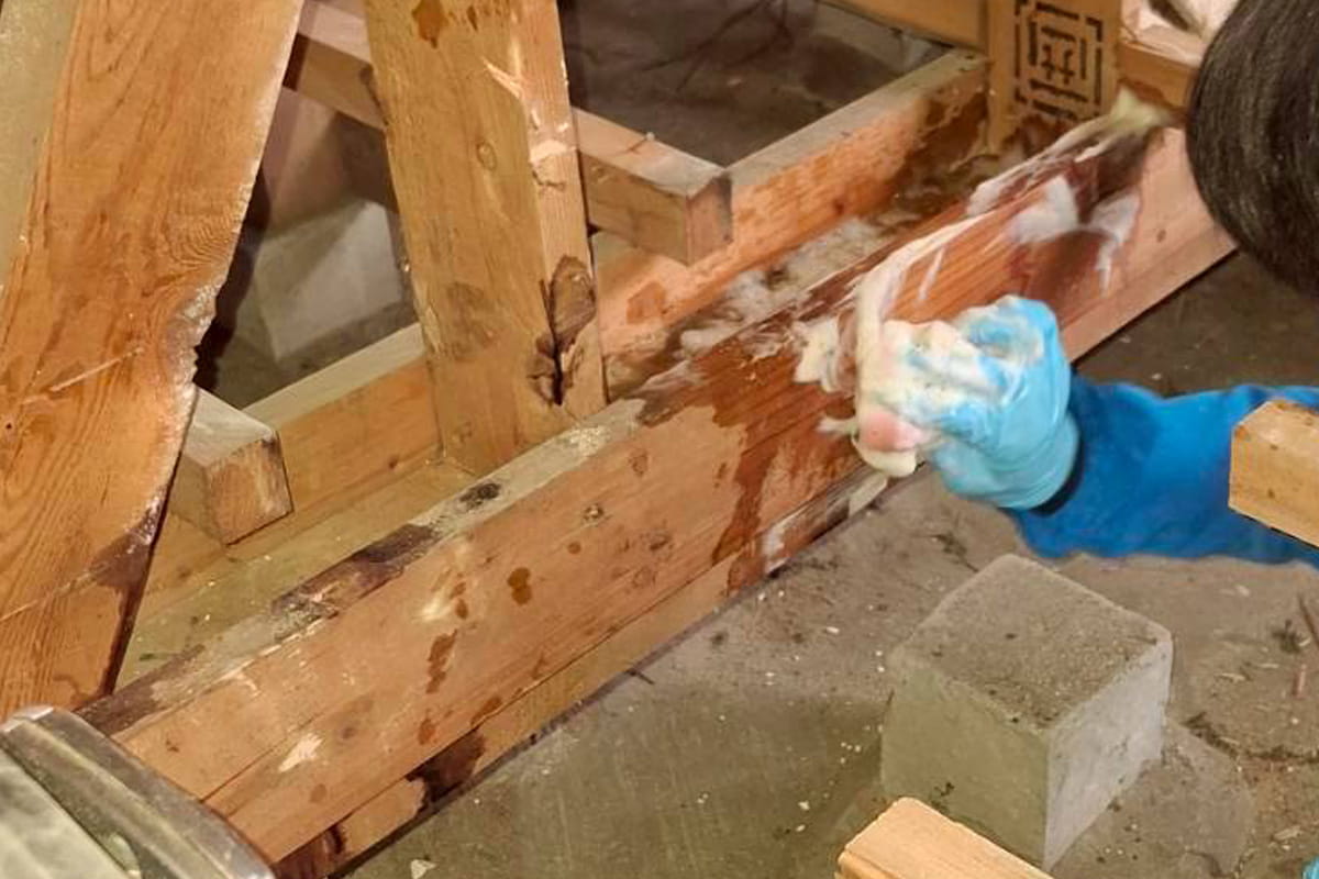 床下の土台柱を拭くロードのスタッフ