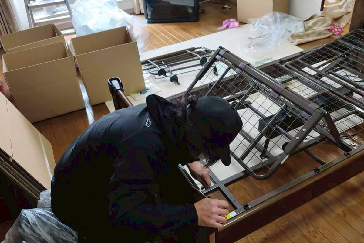 ベットを解体する遺品整理ロードのスタッフ